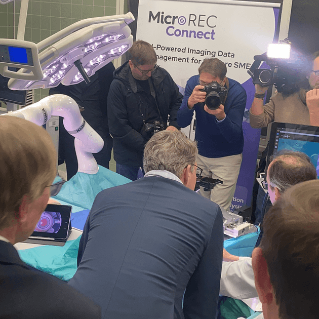 the State Minister for Science and Arts Markus Blume checking the Intravitreal Injection robot and the MicroREC and several photographers in the back