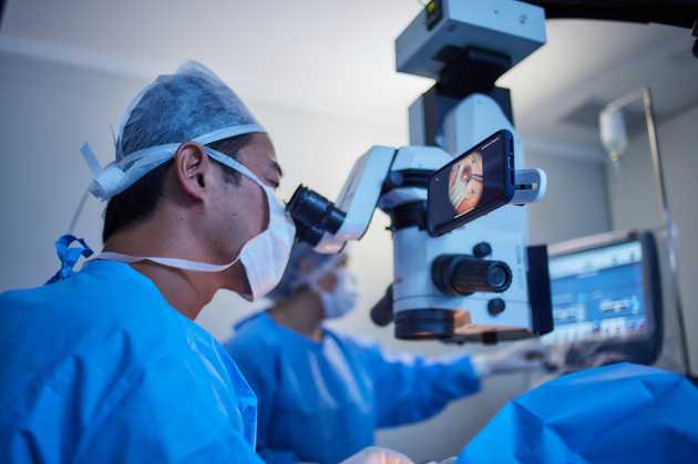 ophthalmologist doing surgery with a phone adaptor (MicroREC) recording it